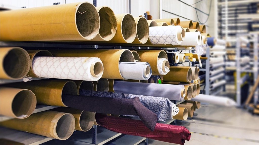 Seeking Out the Finest Weaves and Deciding on the Best Craft Fashion designer inspecting bolts of cloth and manufacturing possibilities